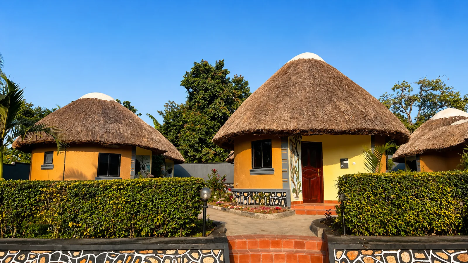 Grass-thatched cottages in Tooro Resort gardens